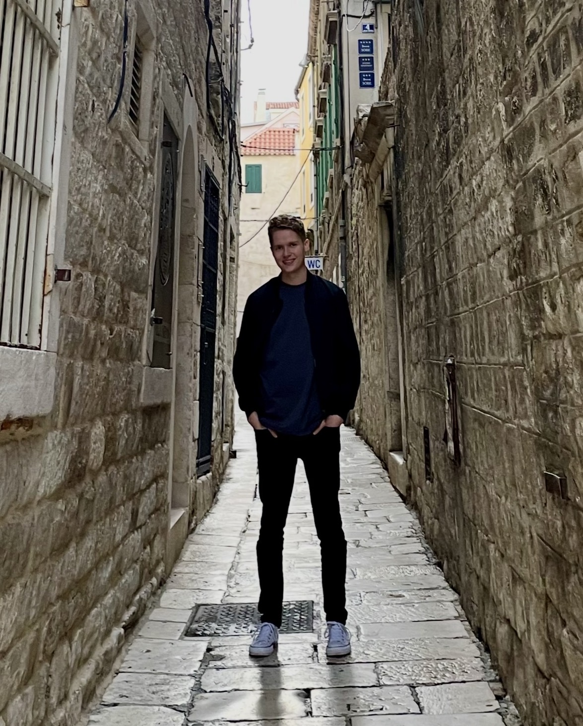 Sean Lundberg standing in a narrow stone alleyway in Croatia